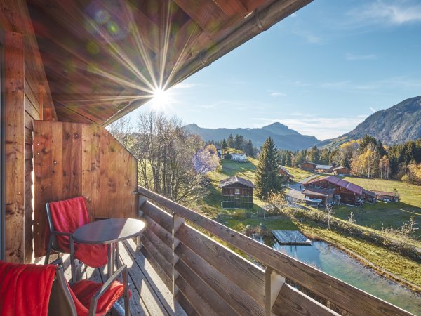 Auf dem Balkon am Doppelzimmer Allgäu Style Superior lässt es sich wunderbar entspannen. Mit Blick zum eigenen Natur Badesee des Hotel Oberstdorf fühlen Sie sich mitten in der Natur angekommen.