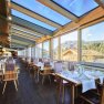 Vom lichtdurchfluteten Wintergarten aus, blicken Sie direkt in ins Grüne. Dieser ist einer von vier ganz unterschiedlich gestalteten Räume im Restaurant im Hotel Oberstdorf.