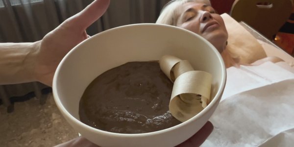 Die Körperpackung bestehend aus der Rosskastanienfrucht und Lehm, wird sanft auf die müden Beine aufgetragen.