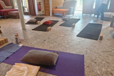 Im Wellnesswohnzimmer der Alpen Wellnesswelt leitet Yoga Profi Maxi Übungen zur inneren Ruhe an.