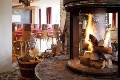 Bei loderndem Feuer genießen die Hotel Oberstdorf - Gäste ihr Abendessen in einem der drei Restaurant - Bereiche.