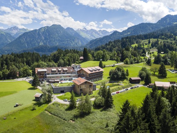 Wellnesshotel im Allgäu umgeben von den Allgäuer Bergen Außenansicht des Hotel Oberstdorfs im Sommer. Im Hintergrund sind die Allgäuer Alpen zu sehen.