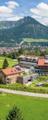 Sommeraufnahme des Hotel Oberstdorfs mit Blick auf Oberstdorf und die Allgäuer Alpen.
