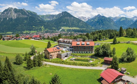 Sommeraufnahme des Hotel Oberstdorfs mit Blick auf Oberstdorf und die Allgäuer Alpen.
