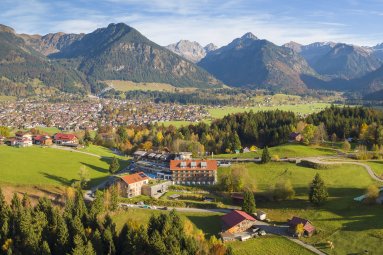 Das Hotel Oberstdorf im goldenen Herbst vor Oberstdorf im Allgäu. Die beeindruckende Bergwelt der Allgäuer Alpen im Hintergrund.