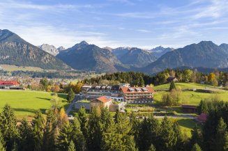 Außenaufnahme vom Hotel Oberstdorf im Herbst mit den Allgäuer Alpen als Hintergrund.