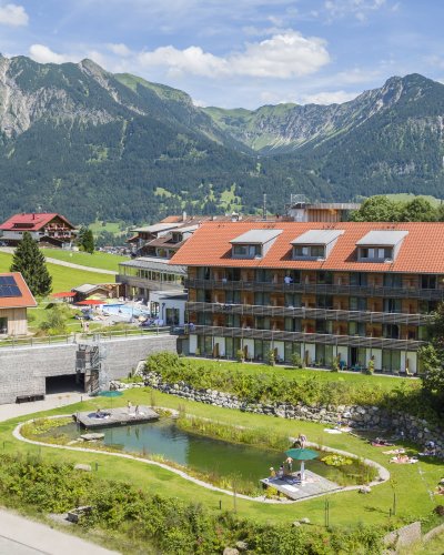 Der Naturbadesee läd an heißen Tagen zum Schwimmen ein. Währenddessen genießen die Gäste des Hotel Oberstdorfs einen traumhaften Blick auf die Bergwelt.