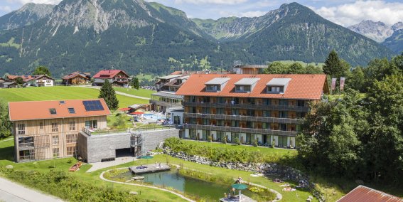 Der Naturbadesee läd an heißen Tagen zum Schwimmen ein. Währenddessen genießen die Gäste des Hotel Oberstdorfs einen traumhaften Blick auf die Bergwelt.