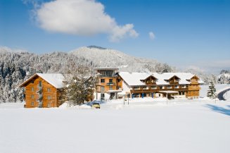 Hotel Oberstdorf im tiefen Schnee mit verschneiten Wäldern und blauem Winterhimmel Das Hotel Oberstdorf im tiefen Allgäuer Winter an einem schönen Wintertag.