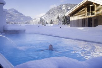 Beheizter Außenpool im Winter mit Blick auf die Allgäuer Berge im Hotel Oberstdorf Kein Angst, Sie müssen nicht in den Schnee treten, bevor sie das herrlich warme Wasser des Pools im Hotel Oberstdorf spüren können. Der Einstieg ins Wasser erfolgt bequem von Innen. Denn auch im Winterurlaub gehört ein Bad für uns dazu.