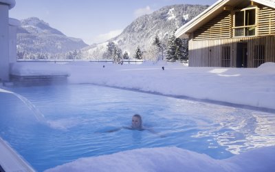 Beheizter Außenpool im Winter mit Blick auf die Allgäuer Berge im Hotel Oberstdorf Kein Angst, Sie müssen nicht in den Schnee treten, bevor sie das herrlich warme Wasser des Pools im Hotel Oberstdorf spüren können. Der Einstieg ins Wasser erfolgt bequem von Innen. Denn auch im Winterurlaub gehört ein Bad für uns dazu.