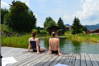 Ein paar Runden schwimmen, den Füßen vom Wandern eine Abkühlung gönnen, oder am Steg die Aussicht genießen - der Badesee am Hotel Oberstdorf sorgt für entspannende Urlaubsmomente im Allgäu.