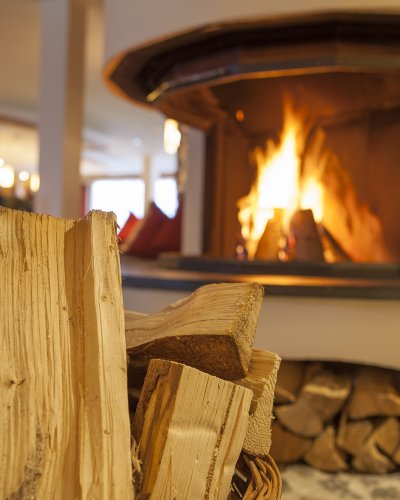 Lodernde Flammen im Kamin strahlen eine wohlige Wärme in der Kaminbar aus.