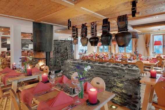 Ein flackerndes Kaminfeuer, stimmungsvolles Kerzenlicht kombiniert mit großen Kuhglocken über einer Steinmauer und ganz besonderen Lampenschirmen - das Ambiente im Alpen Restaurant des Hotel Oberstdorf müssen Sie erlebt haben.