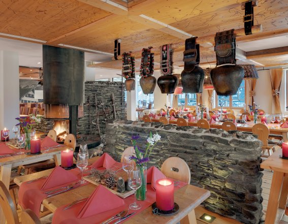 Ein flackerndes Kaminfeuer, stimmungsvolles Kerzenlicht kombiniert mit großen Kuhglocken über einer Steinmauer und ganz besonderen Lampenschirmen - das Ambiente im Alpen Restaurant des Hotel Oberstdorf müssen Sie erlebt haben.