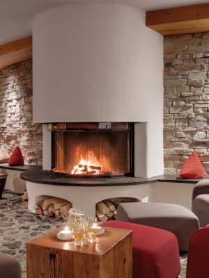Große gemütliche Ohrensessel, ein knisterndes Kaminfeuer und erlesene Getränke finden Sie in der Lounge des Hotel Oberstdorf. Hier lassen sich entspannte Abende im Allgäu verbringen.