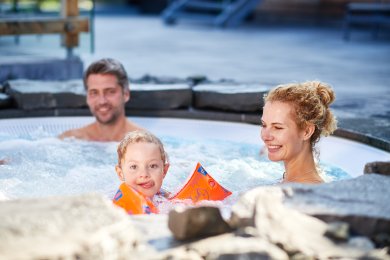 Familienzeit im Außenpool des Hotel Oberstdorf Familie mit Kind beim gemeinsamen Entspannen im beheizten Außenpool des Hotel Oberstdorf – Wellness und Familienzeit im Allgäu.