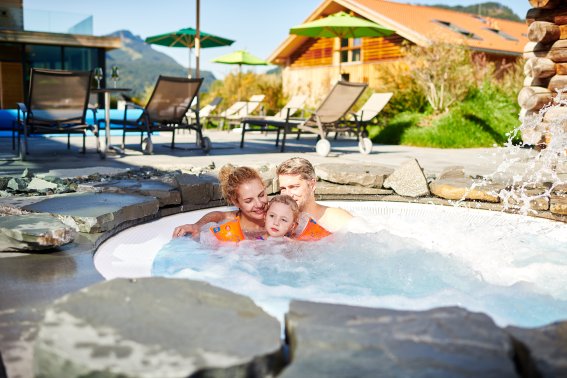 Familie entspannt gemeinsam im Whirlpool der Alpen Wellnesswelt im Hotel Oberstdorf Auszeit im Urlaub, Wellnessangebote im Hotel Oberstdorf