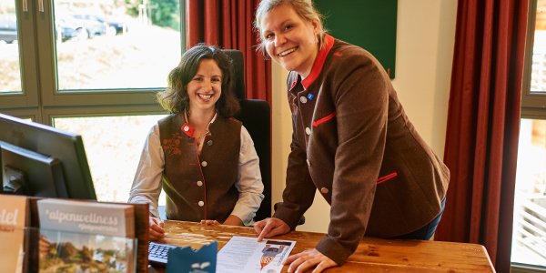 Im Hotel Oberstdorf sind glückliche Mitarbeiter an der Rezeption der erste Ansprechpartner für die Gäste.