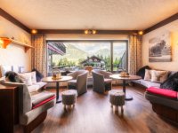 Das Café hat gemütliche Sitzplätze und bietet Aussicht auf die Berge. Kunden können dort entspannen und essen.