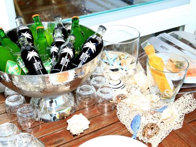 Flasche mit grünen und schwarzen Getränken stehen auf einem Tisch. Neben den Flaschen liegen Gläser und Dekoration.