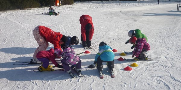 Eine Kindergruppe wärmt sich vor dem Skifahren auf