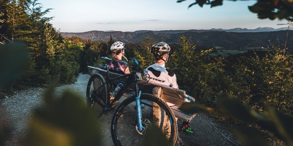 Mountainbiker machen Pause mit Ausblick auf der Adelegg