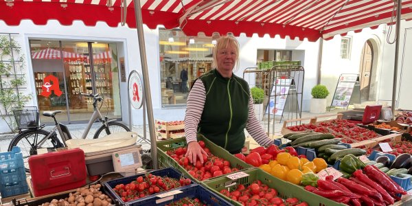 Eine Verkäuferin verkauft frische Tomaten am Stand von Obst und Gemüse Dürrenberger auf dem Isnyer Wochenmarkt.