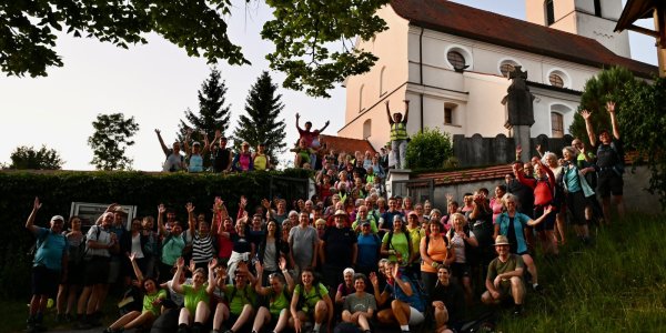 Die Pilger posiert fröhlich vor einer Kirche, nachdem Sie ein Tag und eine Nacht gewandert sind.
