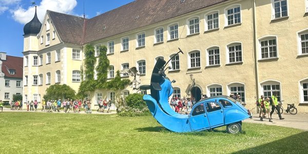 Eine bunte Skulptur zeigt ein Auto als Teil einer Installation im Innenhof des Schloss Isny.