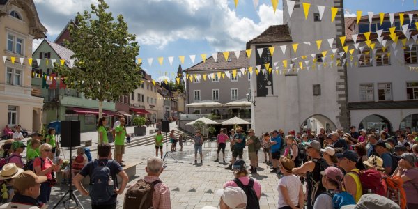 Eine große Gruppe von Menschen versammelt sich auf dem Isnyer Marktplatz zum Start der Pilgerwanderung.