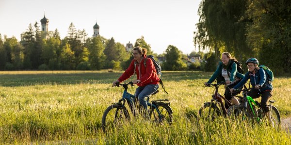 Radfahren mit Blick auf die Türme der Satdt Isny Beim Radfahren rund um Isny werden die historischen Türme in der Ferne gut sichtbar und liefern eine tolle Kulisse.