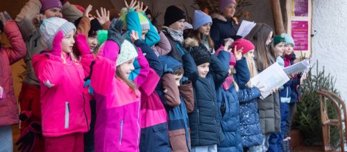 Kinderchöre singen auf der Weihnachtsmarktbühne.