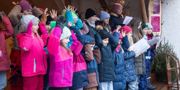 Kinderchöre singen auf der Weihnachtsmarktbühne.