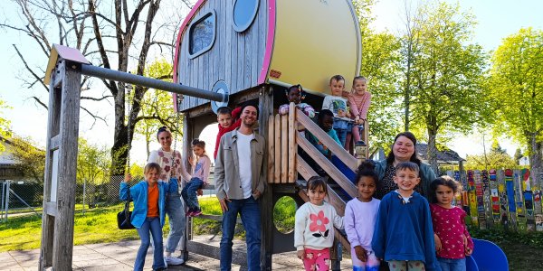 Kinder und Erzieher um Leiter Patrick Thalau freuen sich über den neuen Spielturm im Garten des Kindergartens Felderhalde. Foto: Stadt Isny/Michael Panzram