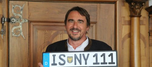 Bürgermeister Rainer Magenreuter mit dem ersten Exemplar der Kennzeichenhalterungen im IsnyAllgäu-Design. Foto: Stadt Isny/Michael Panzram