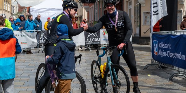 Zwei Radfahrer beglückwünschen sich nach der Zieleinfahrt am Isnyer Marktplatz.