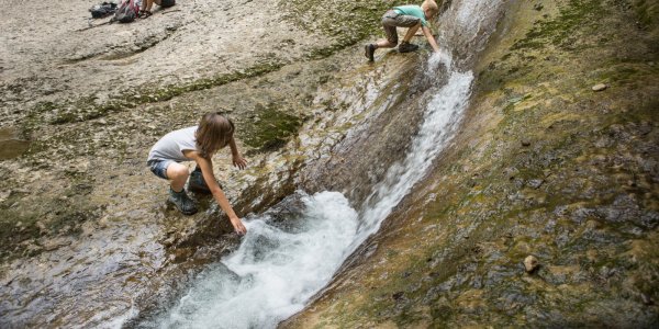 Kinder spielen am Wasser der Oberen Argen im Eistobel.