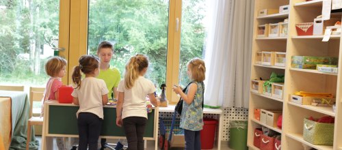Kinder mit ihrem Erzieher in hellen Räumen des Kindergarten Felderhalde