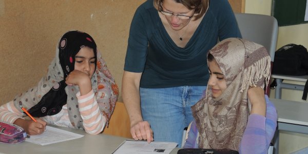Lehrerin mit zwei Schülerinnnen bei der Hausaufgabenbetreuung der Verbundschule Isny