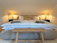 Schlafzimmer mit Doppelbett und zwei Einzelbetten