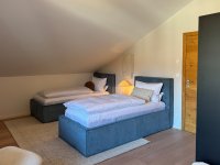 Schlafzimmer mit zwei Einzelbetten und Doppelbett