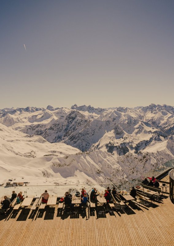 Sonnenterrasse mit Blick auf das verschneite Panorama der Allgäuer Alpen – Winterausflug in die Berge rund um Oberstdorf.