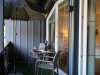 Besuch des Balkons mit Tisch und Stühlen Auf dem Balkon stehen ein Tisch und zwei Stühle. Ein Sonnenschirm bietet Schatten.
