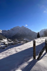 Ein verschneites Gebiet mit Bergen und klarem Himmel. Es ist Winter und die Landschaft ist ruhig und schön.