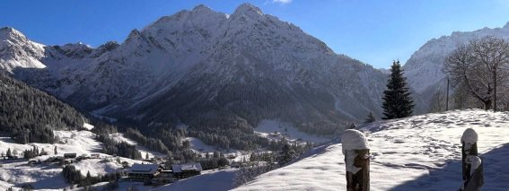 Ein verschneites Gebiet mit Bergen und klarem Himmel. Es ist Winter und die Landschaft ist ruhig und schön.