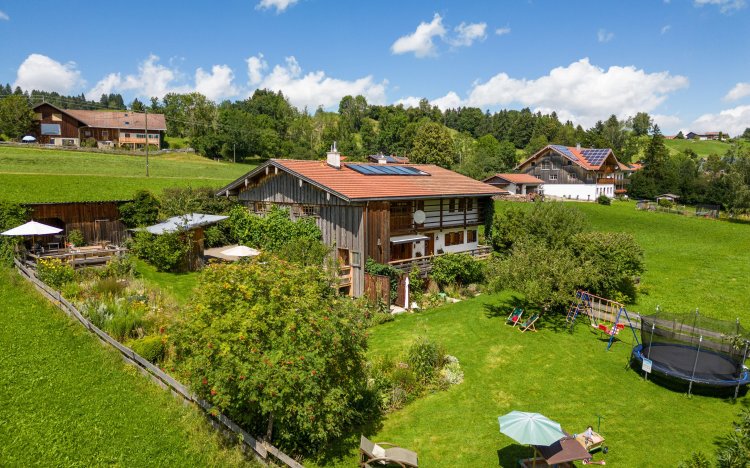 Süd- und Westansicht des Hauses im Sommer vom Grillplatz bis zum Spielplatz