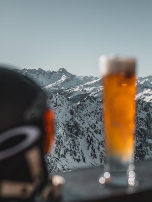 Stärkung mit Bier nach dem Skifahren mit Blick auf die winderlichen Berge