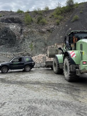 Schweres Gerät transportiert Materialien in einem Steinbruch während des Arbeitstags, um die Baustelle weiter vorzubereiten.