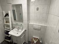 Ein gemütliches Badezimmer, das eine einladende Atmosphäre ausstrahlt. Die Wände sind in sanften, warmen Farben gestrichen, die ein Gefühl von Ruhe und In einer Ecke befindet sich eine moderne Dusche mit einer Glastür, die Licht hereinlässt. Neben der Dusche hängt ein praktischer Handtuchtrockner, der nicht nur für warme Handtücher sorgt, sondern auch einen Hauch von Luxus verleiht. Das WC ist diskret platziert und fügt sich harmonisch in das Gesamtbild ein. Das Waschbecken ist funktional, mit ausreichend Platz für Pflegeprodukte. Über dem Waschbecken hängt ein großer Spiegel, der den Raum zusätzlich aufhellt. Ein Fön ist ebenfalls vorhanden, praktisch für die schnelle Haarpflege nach dem Duschen. Flauschige Handtücher stehen zu Verfügung.